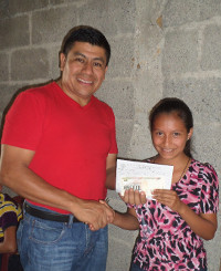 Eduardo übergibt Bescheinigung für Stipendium an eine Stipendiatin